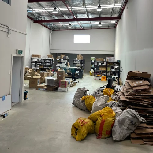 First warehouse filled with boxes, bags, shelves, and orders ready for shipping, marking the $1M milestone in Billy’s business journey